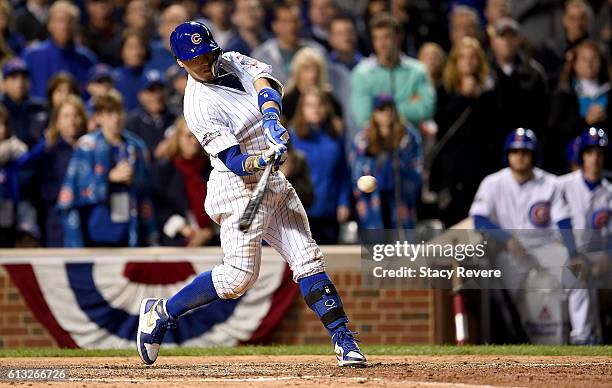 Javier Baez of the Chicago Cubs hits a home run in the eighth inning against the San Francisco Giants at Wrigley Field on October 7, 2016 in Chicago,...