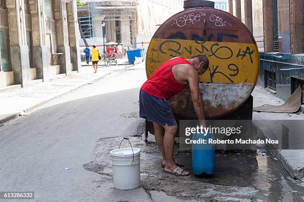 Man fetching water from a water distribution tank. It distributes water to neighbours in Old Havana.