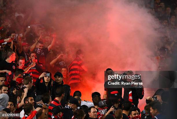 Wanderers fans look on as a flare is lit during the round one A-League match between the Western Sydney Wanderers and Sydney FC at ANZ Stadium on...