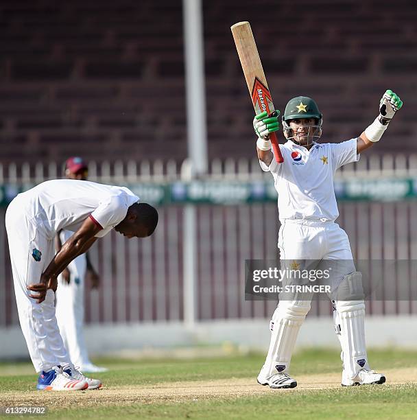 Pakistan's batsman Adnan Akmal lifts up his bat after scoring half century during the second day of the tour match between Pakistan Cricket Board...