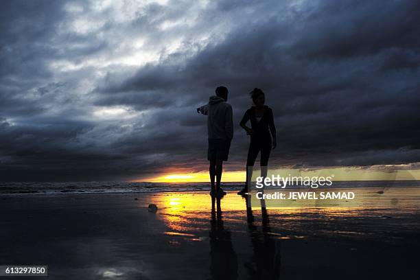 Couple watch the sunrise in Jacksonville Beach, Florida, on October 8 after hurricane Matthew passed the area. A weakened Hurricane Matthew churned...