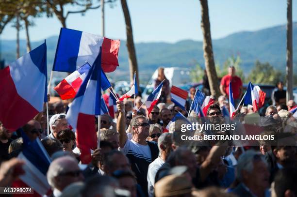 French far-right Front National 's supporters wave French national flag as they take part in a rally against the possibilty of welcoming refugees in...