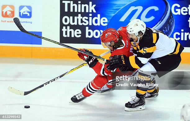 Matthew Philip of the Niagara IceDogs and Liam Murray of the Kingston Frontenacs battle for the puck during an OHL game at the Meridian Centre on...