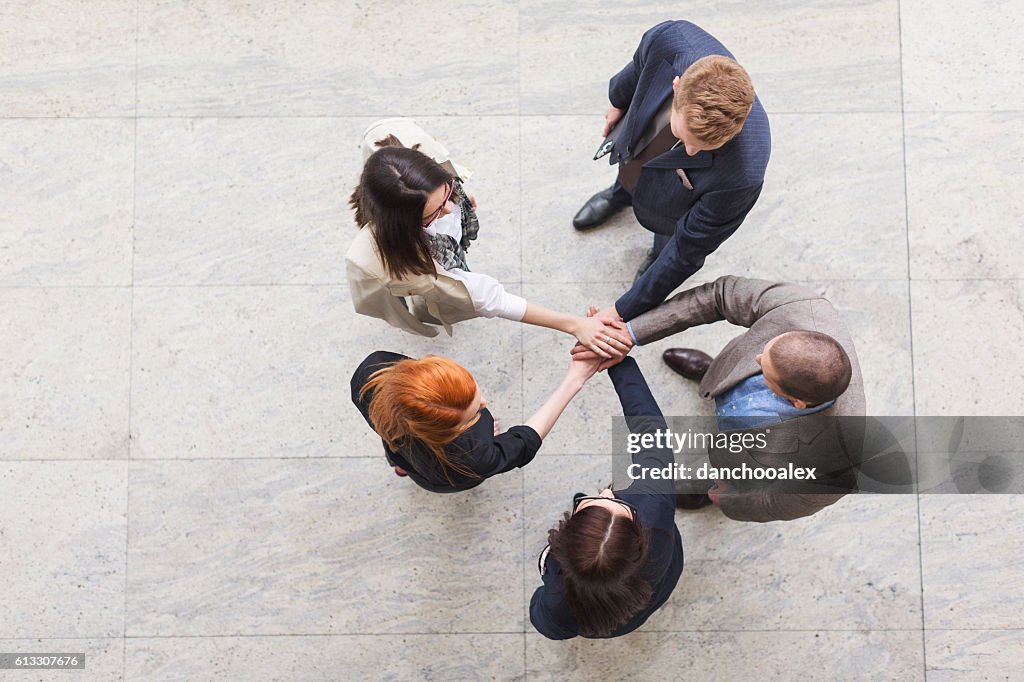 Business team joyning hands high angle view