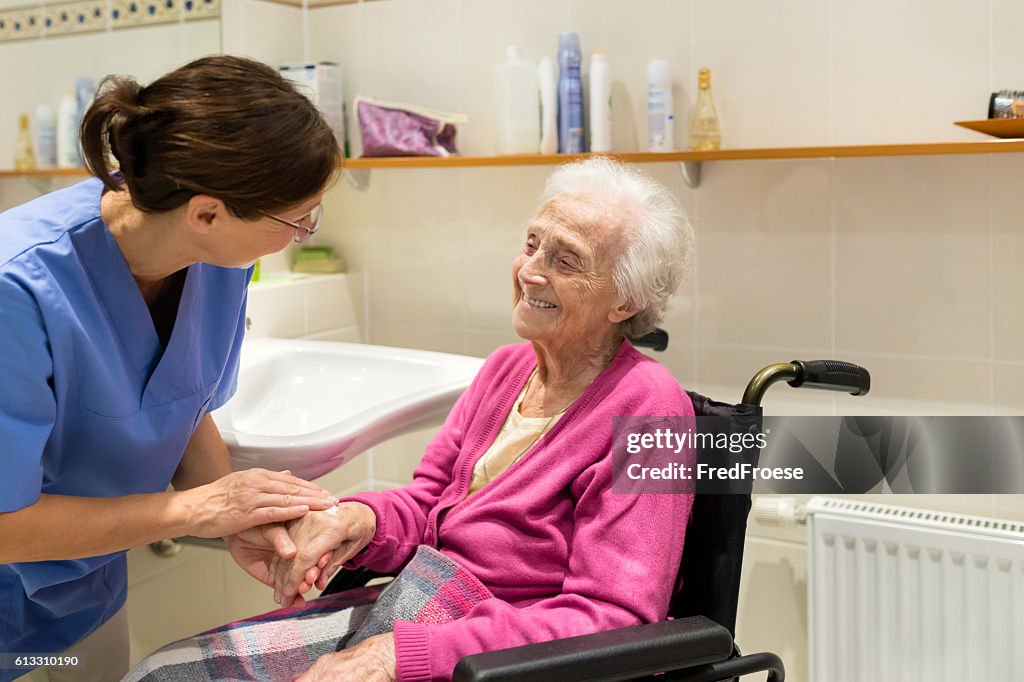 Home Caregiver con donna anziana in bagno