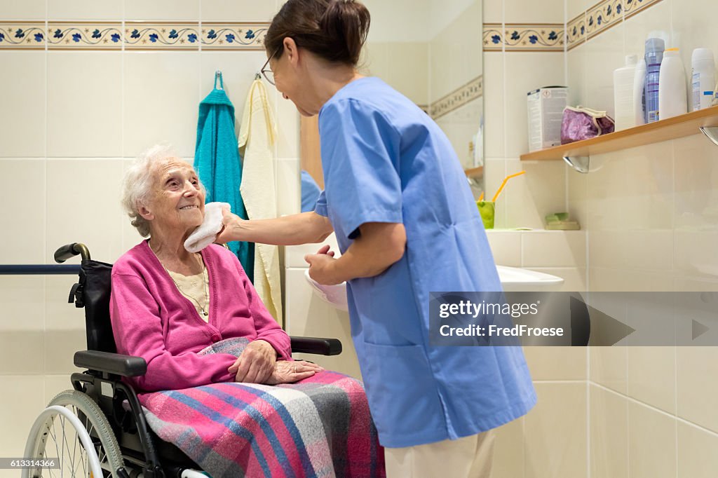 Home Caregiver with senior woman in bathroom