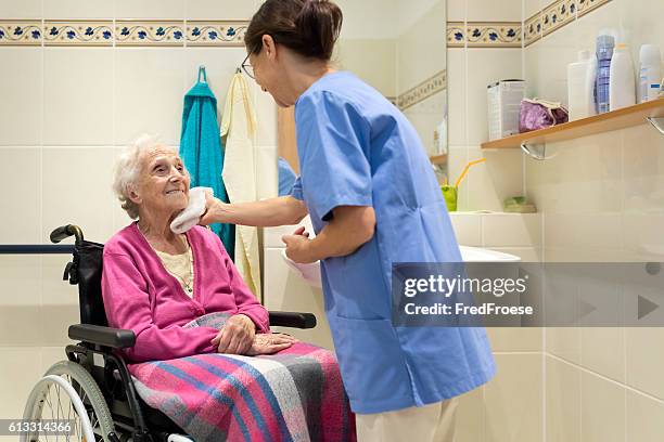 home caregiver with senior woman in bathroom - hygiene 個照片及圖片檔