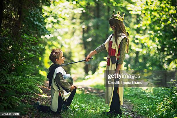 queen knighting her loyal knight in forest - kneeling stock pictures, royalty-free photos & images