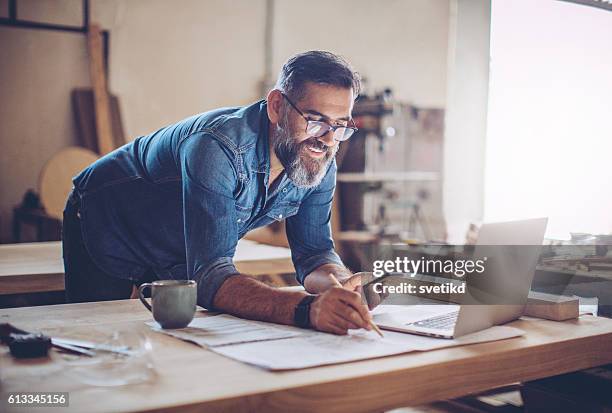 technologie war eine große hilfe in diesem business - smiling professional at work tools stock-fotos und bilder