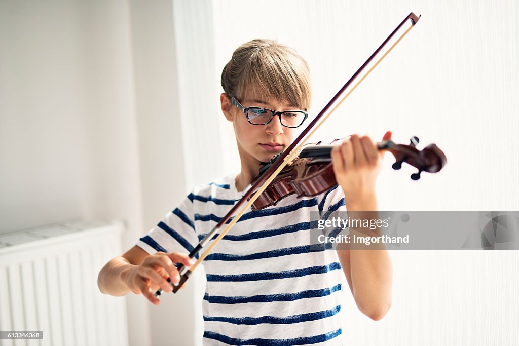 Teenager-Mädchen spielen Geige zu Hause