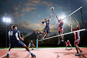 Professional volleyball players in action on the night court