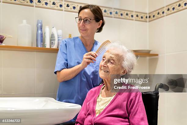 home caregiver mit seniorin im badezimmer - pflege stock-fotos und bilder