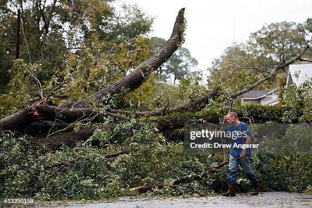 Rudd Long examines an elm tree that fell in front of his home, October 8, 2016 in Savannah, Georgia. Across the Southeast, Over 1.4 million people...