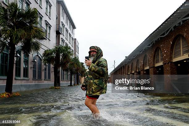 Local tour guide Larry Gerald live streams himself on social media as he crosses flooded S. Market Street at East Bay St. In the wake of Hurricane...