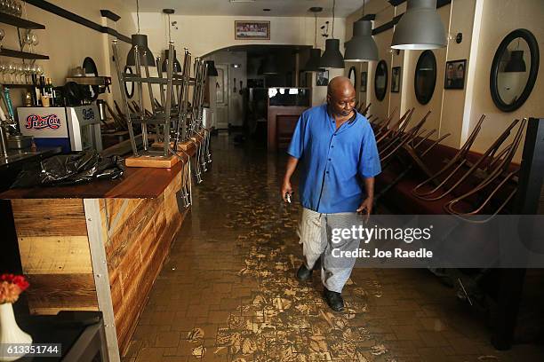 Eugene Scott walks through the muck on the floor of Athena Restaurant after it was flooded by water as Hurricane Matthew passed through the area on...
