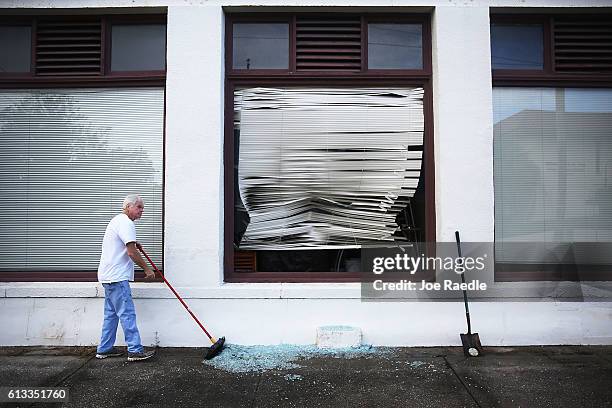 John Dennehy cleans up broken glass after a window was broken when Hurricane Matthew passed through the area on October 8, 2016 in St Augustine,...
