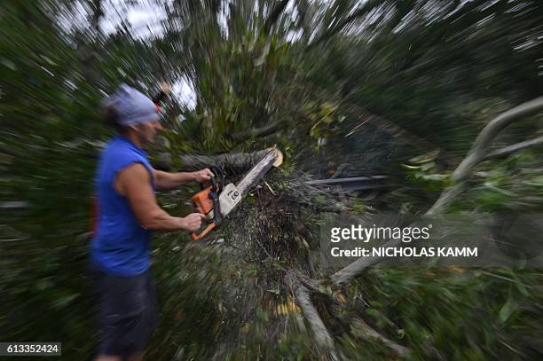 Man cuts a tree blocking access to the Frederick Hhn Bridge leading to Tybee Island in Savannah, Georgia, on October 8 after Hurricane Matthew hit...