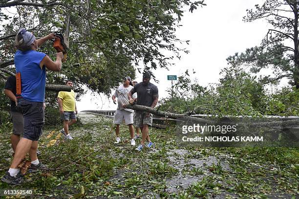 People remove tree limbs from a tree blocking access to the Frederick Hhn Bridge leading to Tybee Island in Savannah, Georgia, on October 8, 2016...