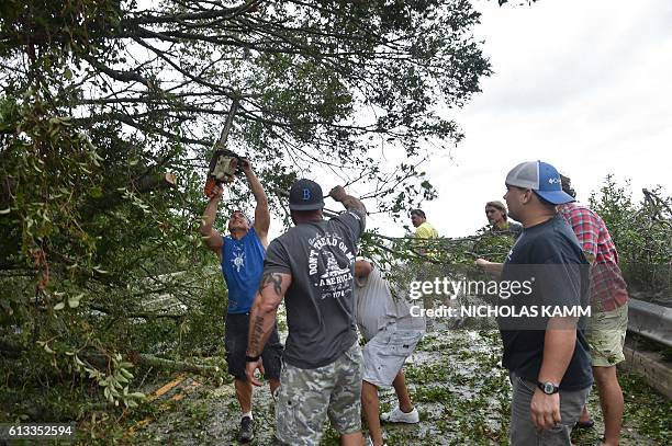 People remove tree limbs from a tree blocking access to the Frederick Hhn Bridge leading to Tybee Island in Savannah, Georgia, on October 8, 2016...