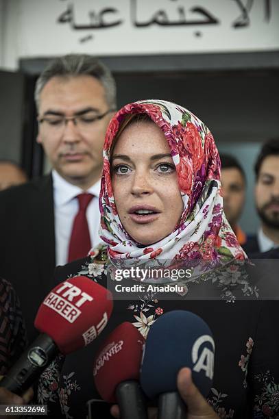 American actress Lindsay Lohan speaks to press members with wearing a headscarf given by a Syrian woman, after her visit at a container town where...