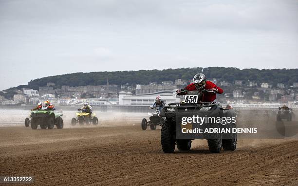 Riders race down the beach during the Adult Quad and Sidecar race during the 2016 HydroGarden Weston Beach Race in Weston-super-Mare, south west...