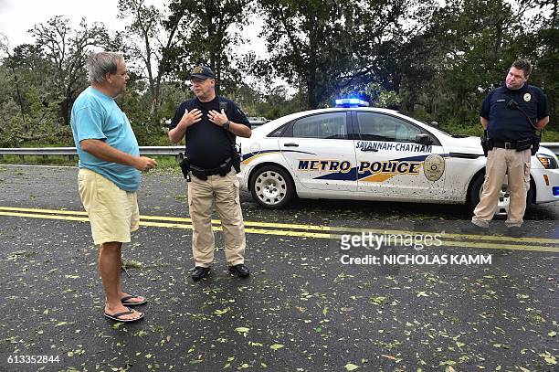 Resident of Tybee Island speaks with police blocking access to the Frederick Hahn Bridge leading to the island in Savannah, Georgia, on October 8,...