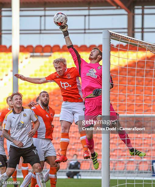 Blackpool's Mark Cullen jumps for a header which Cambridge United's Will Norris pushes to safety during the Sky Bet League Two match between...