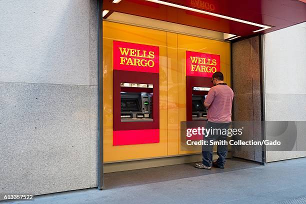 Man uses a Wells Fargo Automated Teller Machine outside headquarters of Wells Fargo Capital Finance, the commercial banking division of Wells Fargo...