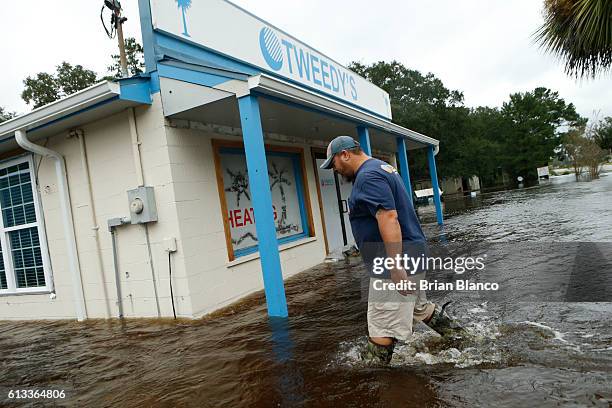 McCLELLANVILLE, SC John Tweedy wades into the swift-moving floodwater surrounding his business as he inspects damage in the wake of Hurricane Matthew...