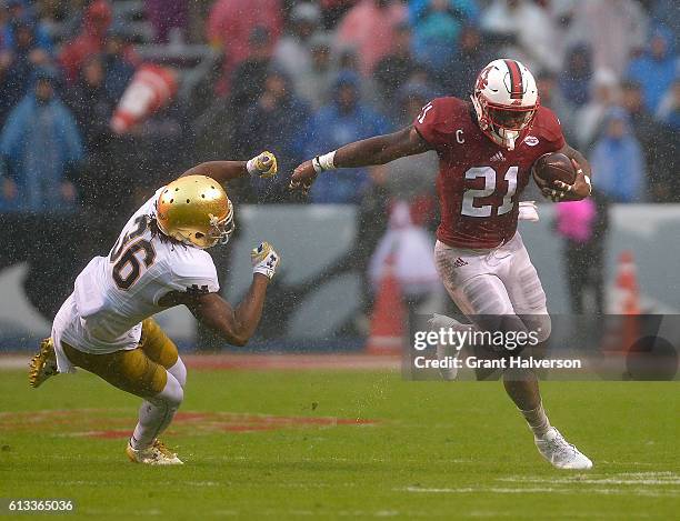 Matthew Dayes of the North Carolina State Wolfpack breaks away from Cole Luke of the Notre Dame Fighting Irish during the game at Carter Finley...