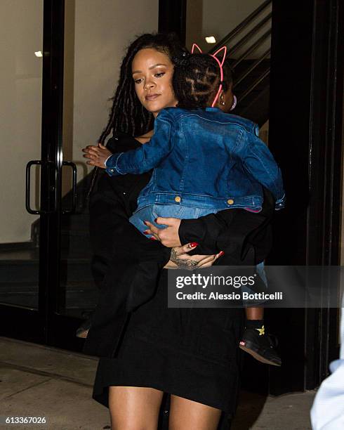 Rihanna carries her cousin Majesty as they head to Paint Box nail salon in SoHo on October 7, 2016 in New York, New York.