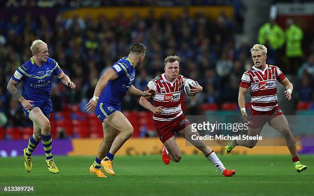 Dan Sarginson of Wigan runs at Tom Lineham and Rhys Evans of Warrington as team mate Lewis Tierney supports during the First Utility Super League...