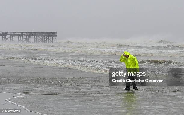 David Reedy of Wilkes County, N.C., walks from the surf created by Hurricane Matthew near the pier on the Isle of Palms in South Carolina on...