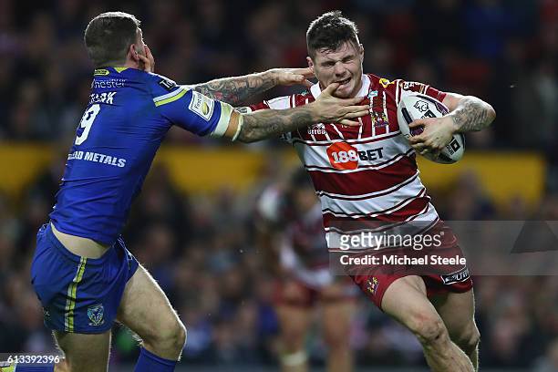 John Bateman of Wigan feels the challenge from Daryl Clark of Warrington during the First Utility Super League Final between Warrington Wolves and...