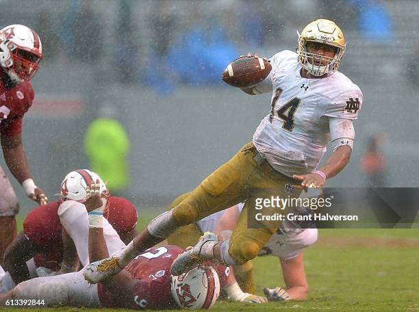 Bradley Chubb of the North Carolina State Wolfpack trips up DeShone Kizer of the Notre Dame Fighting Irish for a sack during the game at Carter...