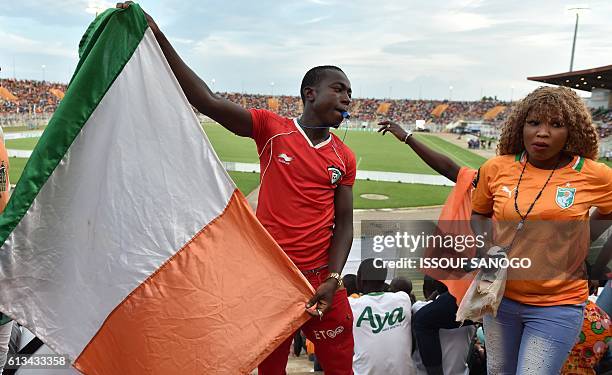 An Ivory Coast's National football team supporter holds a national flag during the FIFA World Cup 2018 football qualification match between Ivory...