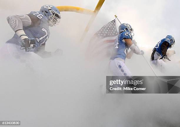 Cayson Collins, Ayden Bonilla, and R.J. Prince of the UNC Tar Heels take the field against the Virginia Tech Hokies at Kenan Stadium on October 8,...