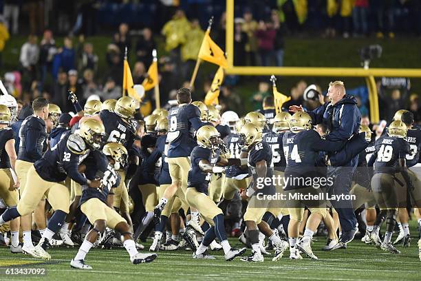 Navy Midshipmen fans run on the field after a football game against the Houston Cougars at Navy-Marines Memorial Stadium on October 8, 2016 in...