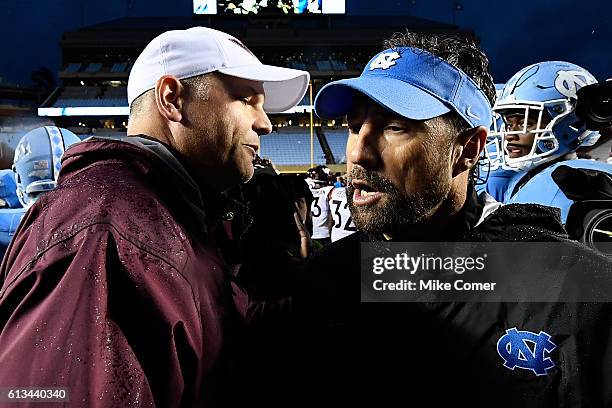 Head coach football Larry Fedora of the UNC Tar Heels shakes hands with head coach Justin Fuente of the Virginia Tech Hokies following their game at...