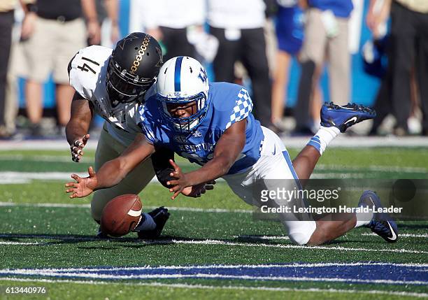 Kentucky linebacker Eli Brown, right, comes up with the ball after Vanderbilt safety Ryan White fumbled a punt in the first quarter at Commonwealth...