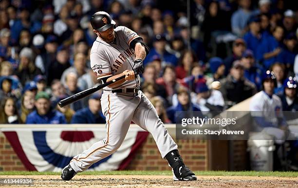 Madison Bumgarner of the San Francisco Giants reaches on an error in the fifth inning against the Chicago Cubs at Wrigley Field on October 8, 2016 in...