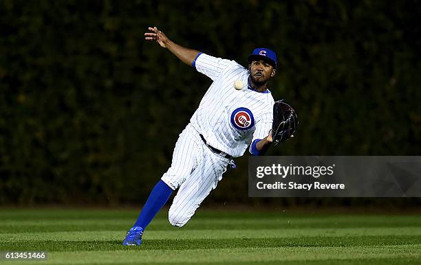 Dexter Fowler of the Chicago Cubs dives to make a catch in the ninth inning against the San Francisco Giants at Wrigley Field on October 8, 2016 in...