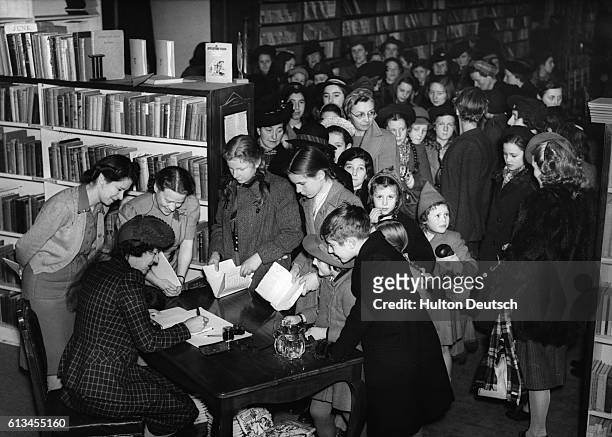 Enid Blyton the children's author, signs autographs for queues of waiting fans in a Brompton Store, London. She is popular for among others, her...
