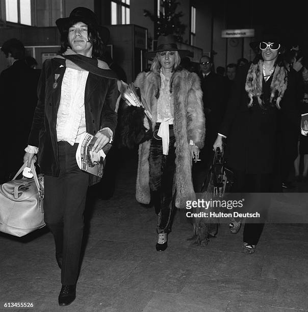 Mick Jagger, Keith Richards of The Rolling Stones, and Keith's girlfriend Anita Pallenberg leave London from Heathrow Airport to look for a South...