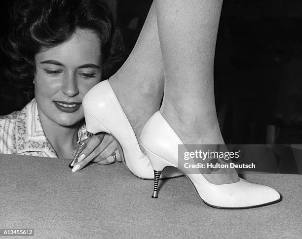 Model at the 12th Fashion in Footwear show wears a pair of leather court shoes by Norvic, with screw-in, stiletto heels. The heels come in two...