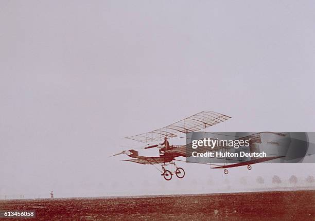 An experimental biplane, piloted by the French aviator Henri Farman, during a low level flight.