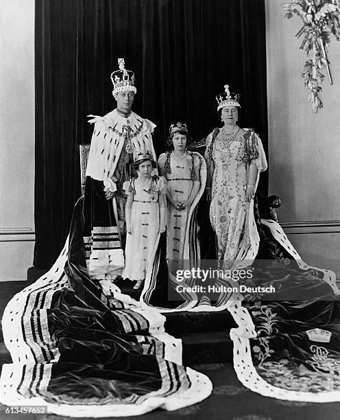 King George VI and Queen Elizabeth of England with their daughters Princess Elizabeth and Princess Margaret in their coronation robes.