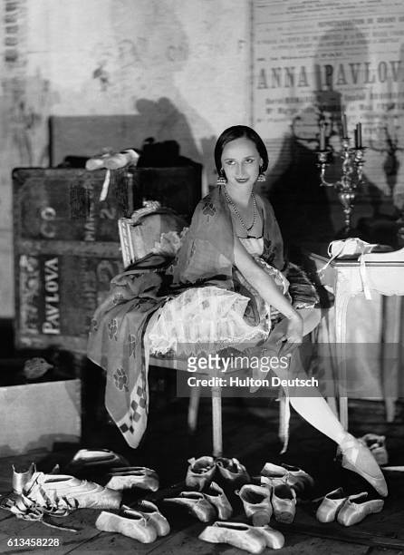 Russian prima ballerina Anna Pavlova prepares her many pairs of ballet slippers in her dressing room before a performance in Paris.