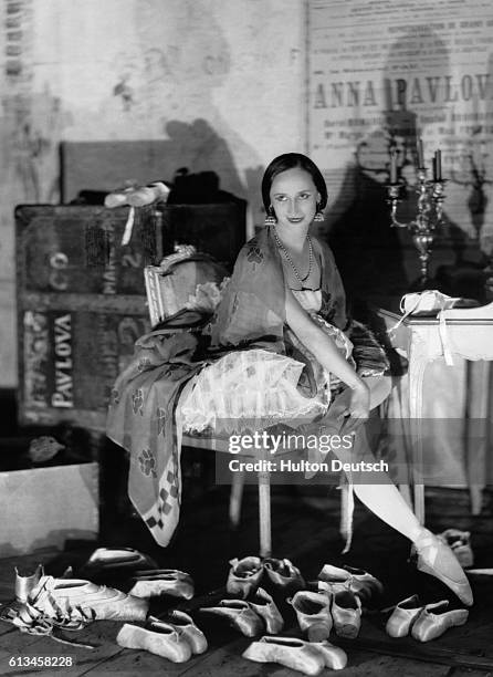 Russian prima ballerina Anna Pavlova prepares her many pairs of ballet slippers in her dressing room before a performance in Paris.