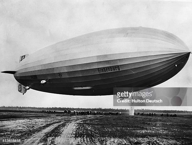 The Hindenburg dumps a small flood of water onto the navy field, in Lakehurst N. J., to ensure a smooth landing.